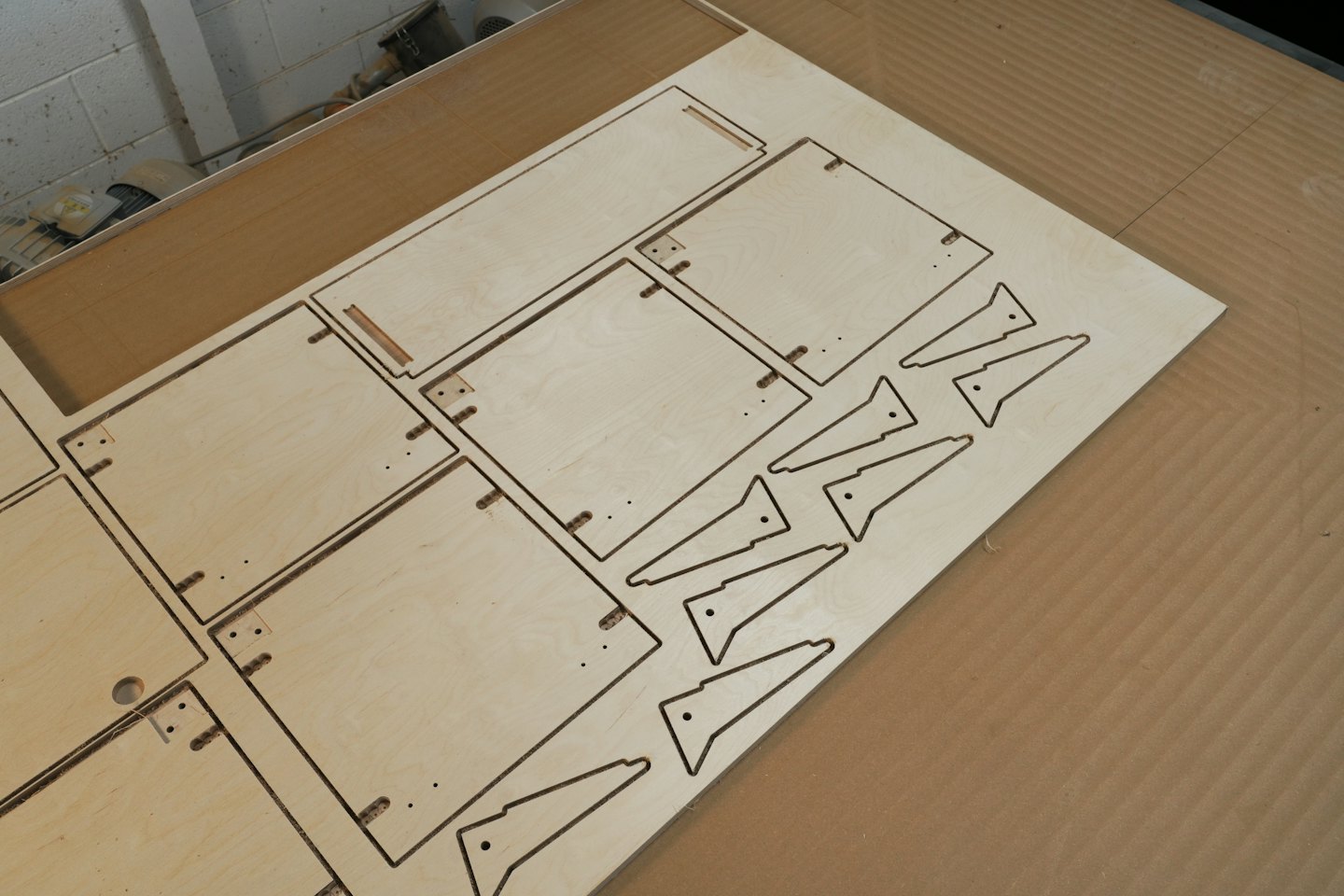 Plaque de contreplaqué découpée au laser avec des motifs géométriques sur une table.