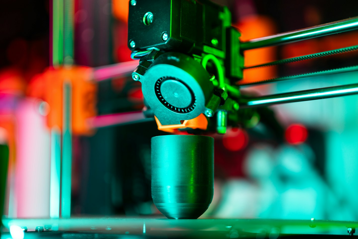 Buse d'imprimante 3D déposant de la matière fondue sur un objet métallique.