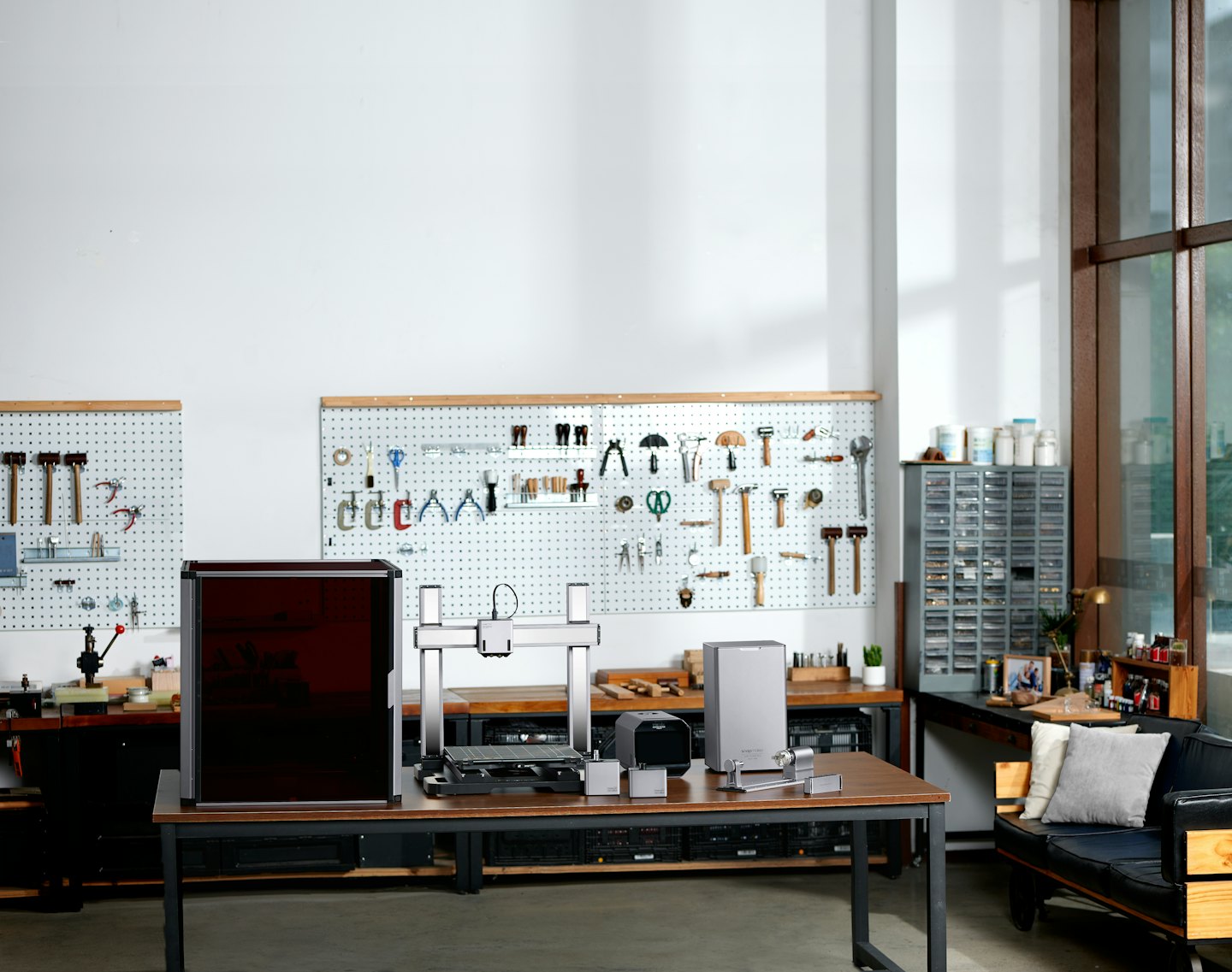 Espace de création moderne avec imprimante 3D et outils sur une table.
