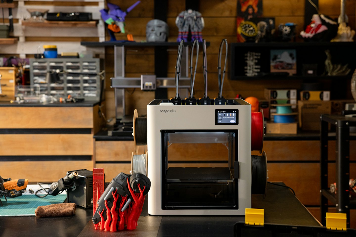 Imprimante 3D Snapmaker sur un établi avec des outils et des fournitures.